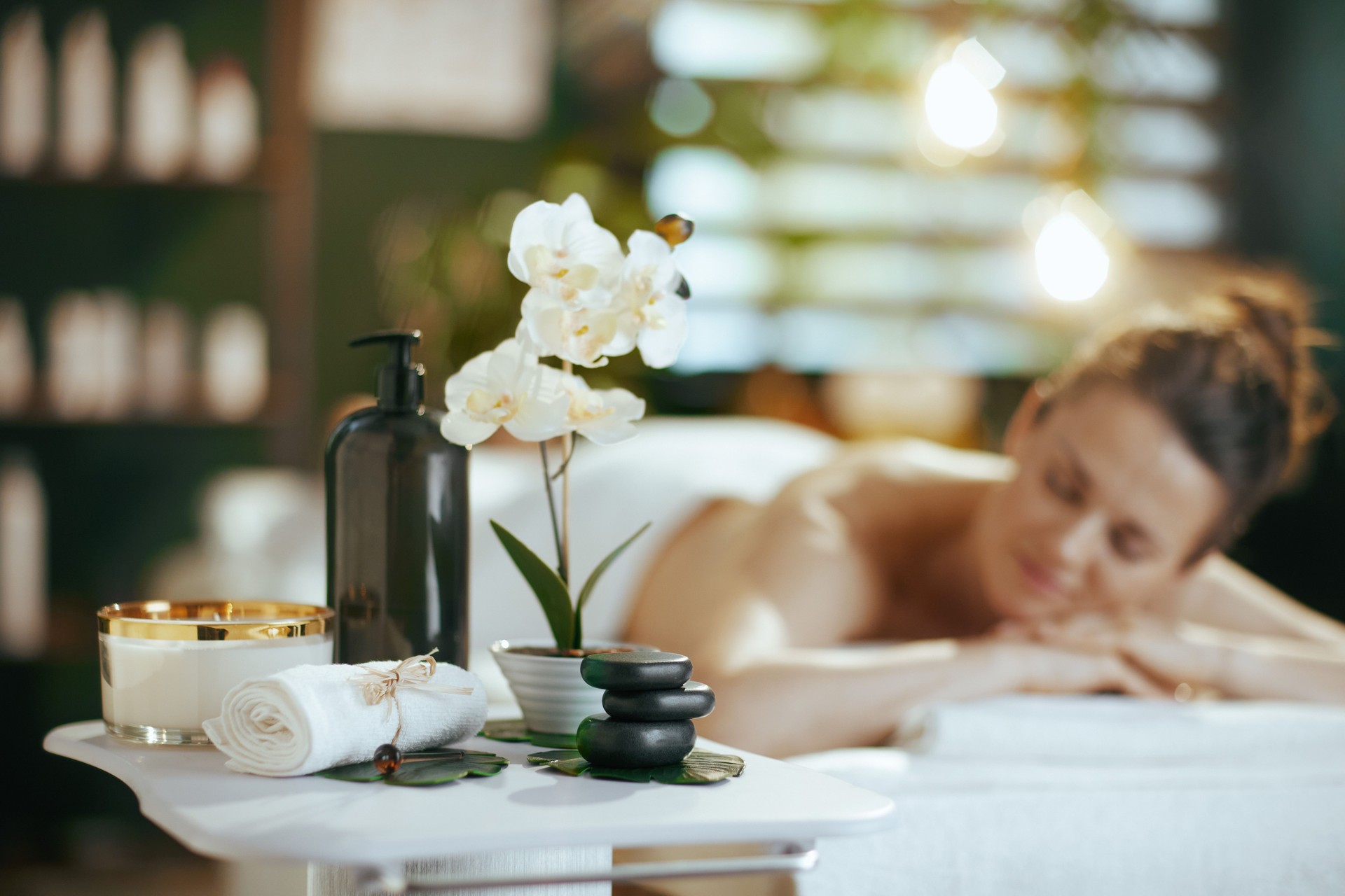 Relaxed woman in spa salon laying on massage table